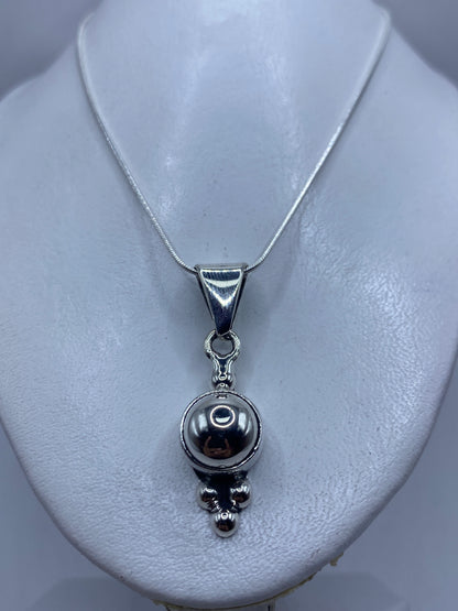 Esfera minimalista de plata contra fondo blanco mostrando el brillo del pulido