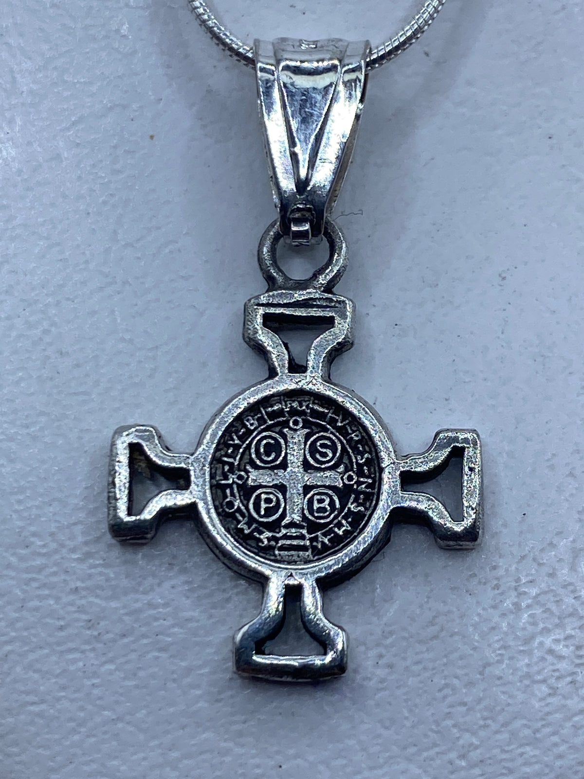 Dije cruz San Benito calado en plata .925 con medallón central grabado