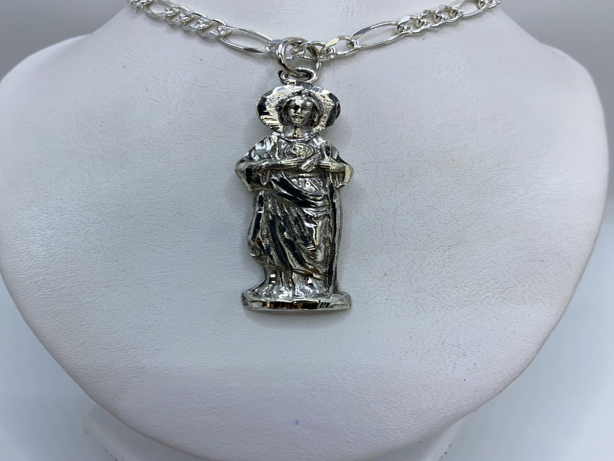 Dije de plata repujado con figura religiosa clásica de Taxco, colgado en cadena de eslabones