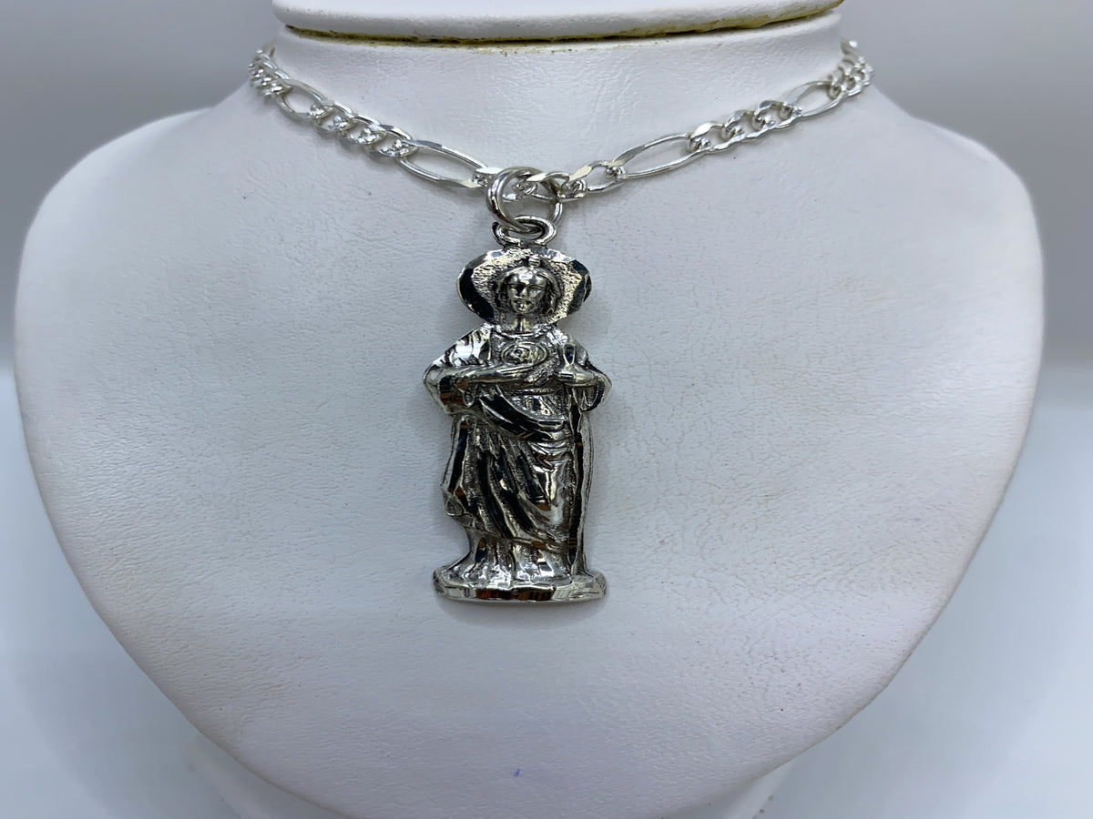 Detalle del repujado manual en la figura religiosa — técnica de martillado de Taxco