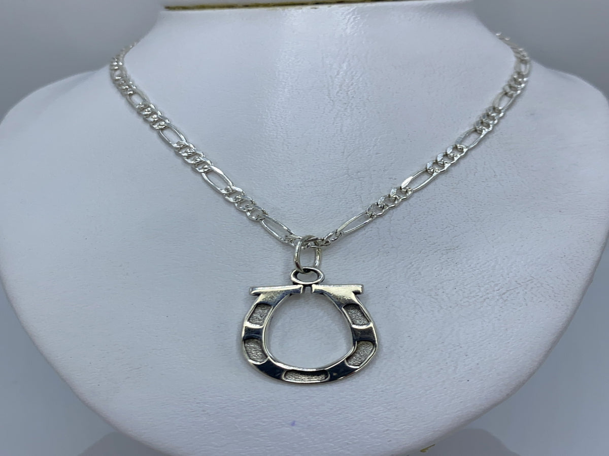 Detalle del dije de plata con acabado artesanal y líneas geométricas