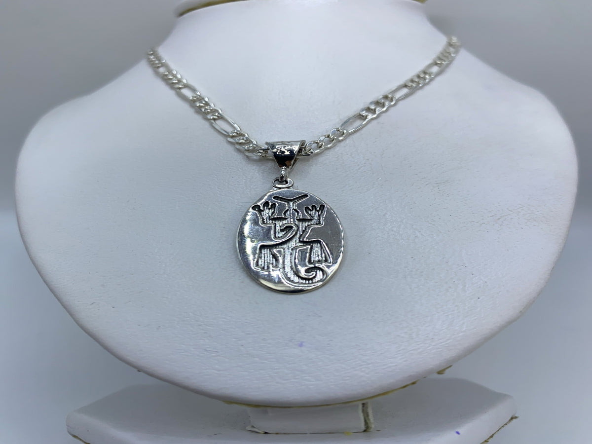 Dije prehispánico sobre cadena figaro de plata, visto al cuello