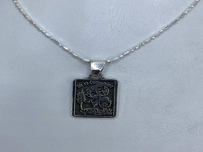Detalle del diseño repujado del dije religioso de Taxco