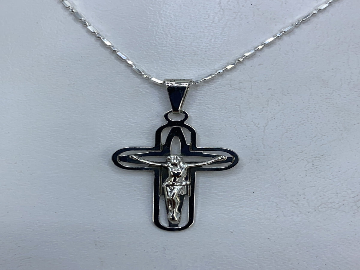 Dije crucifijo de plata .925 con calado, frente donde se ve el relieve y los cortes delicados