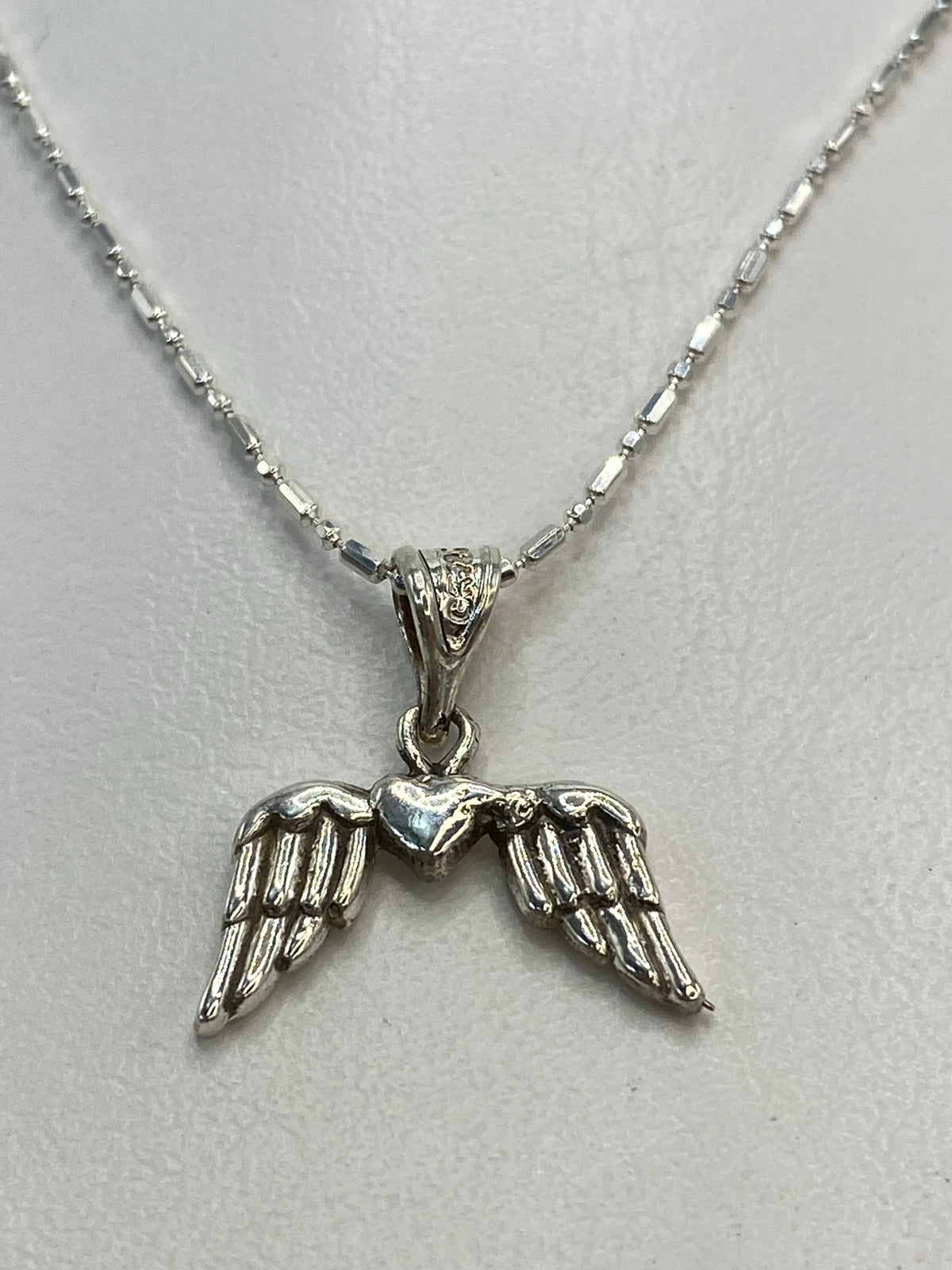 Detalle del repujado en las alas del dije de plata de Taxco