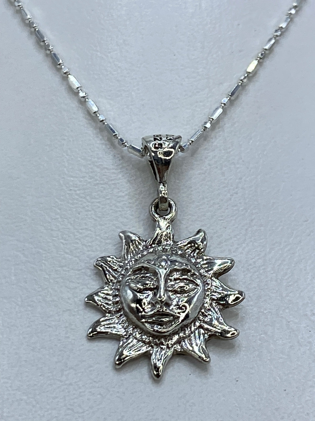 Detalle del repujado: relieve profundo del sol de 2 cm con expresión tallada a mano