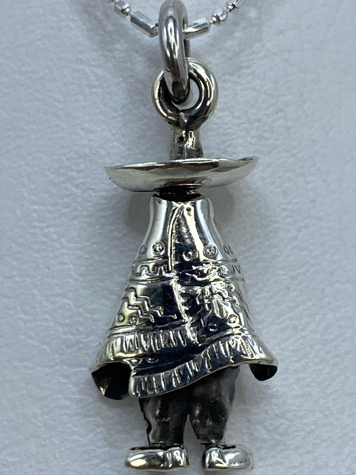 Dije de plata prehispánico visto en escala de centímetros, mostrando el tamaño de 3 cm