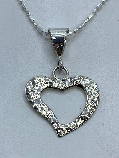 Dije de plata repujado en forma de corazón sobre cadena de plata brillante