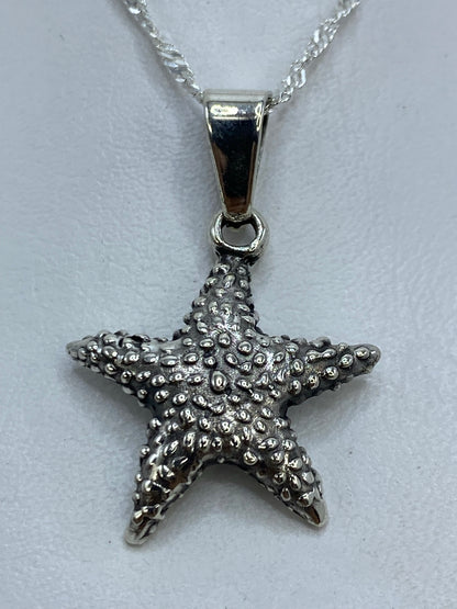Dije de plata en forma de estrella de mar con textura de granulado