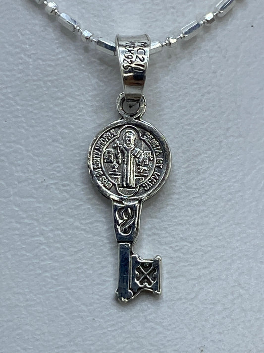Dije San Benito de plata .925 repujado, frente con la imagen del santo en relieve