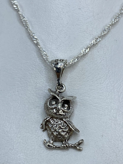 Dije búho fundido en plata con alas en relieve