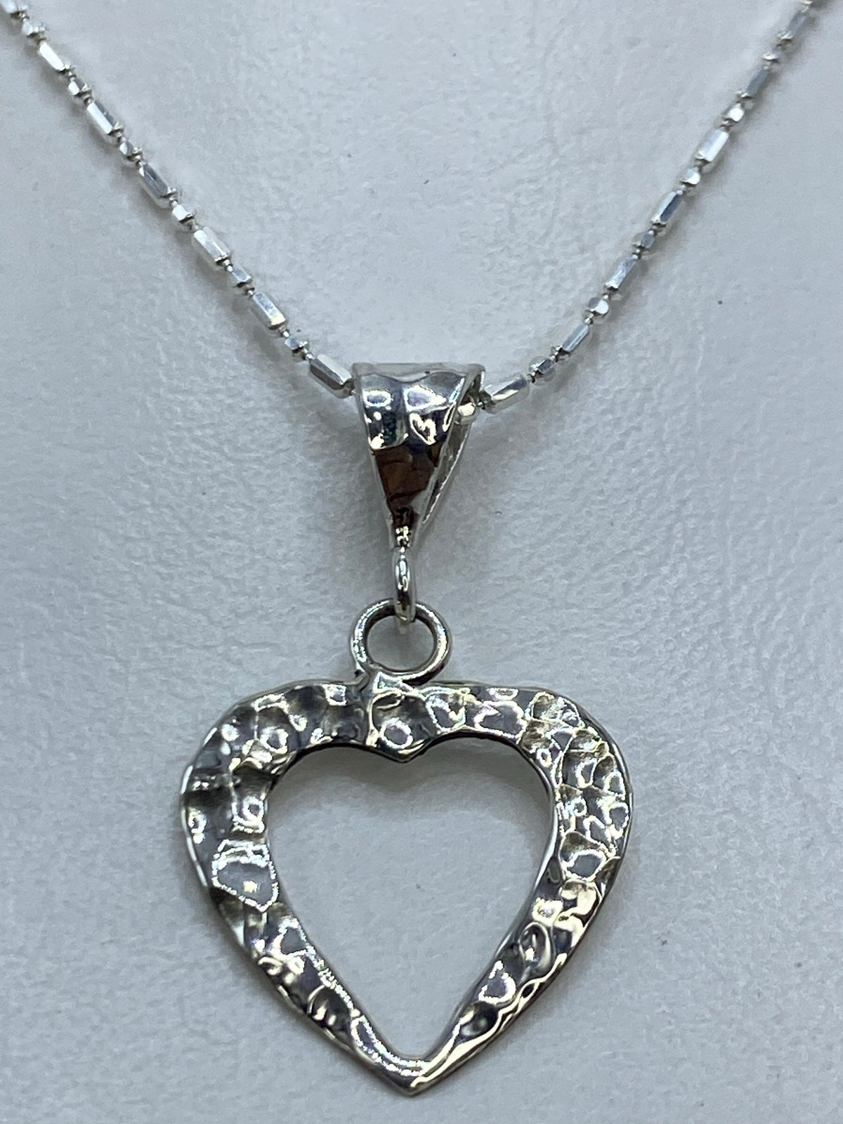 Detalle del corazón abierto en plata .925 mostrando el acabado combinado pulido