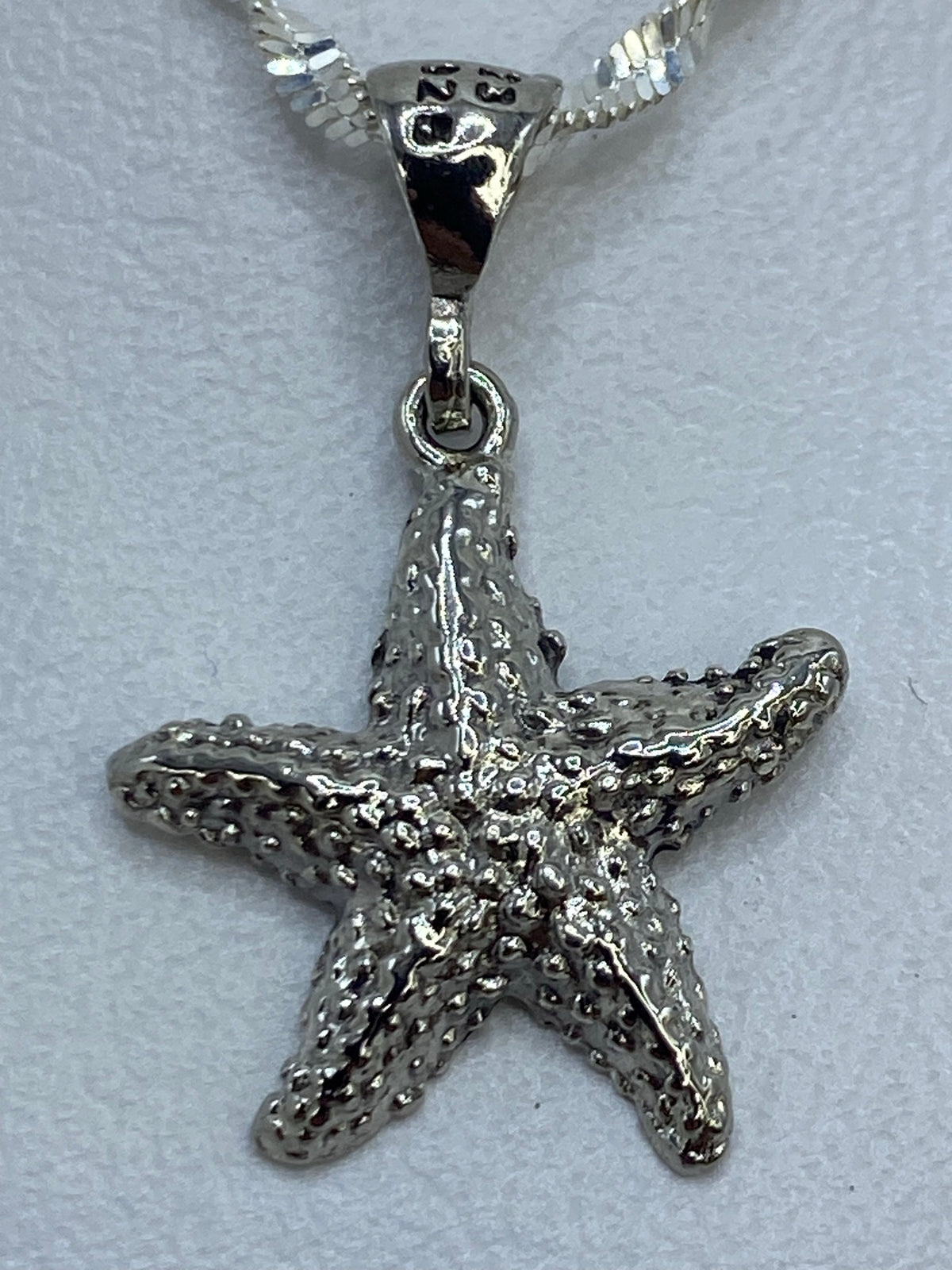 Dije de 2 cm de largo de estrella de mar en plata .925 sobre metro de escala