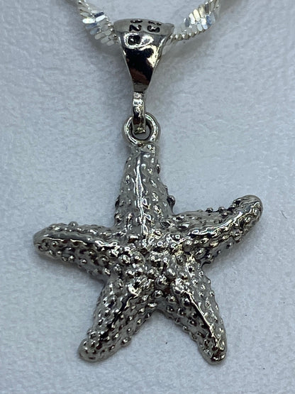 Dije de 2 cm de largo de estrella de mar en plata .925 sobre metro de escala
