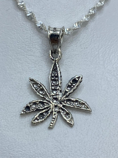 Dije de plata ocho pétalos de 3 cm de largo sobre cadena plateada