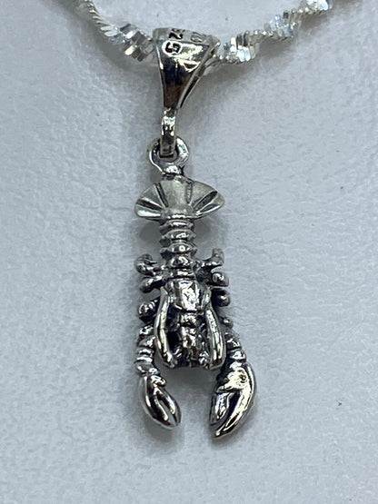 Dije de plata langosta con pinzas definidas, colgado de cadena plateada