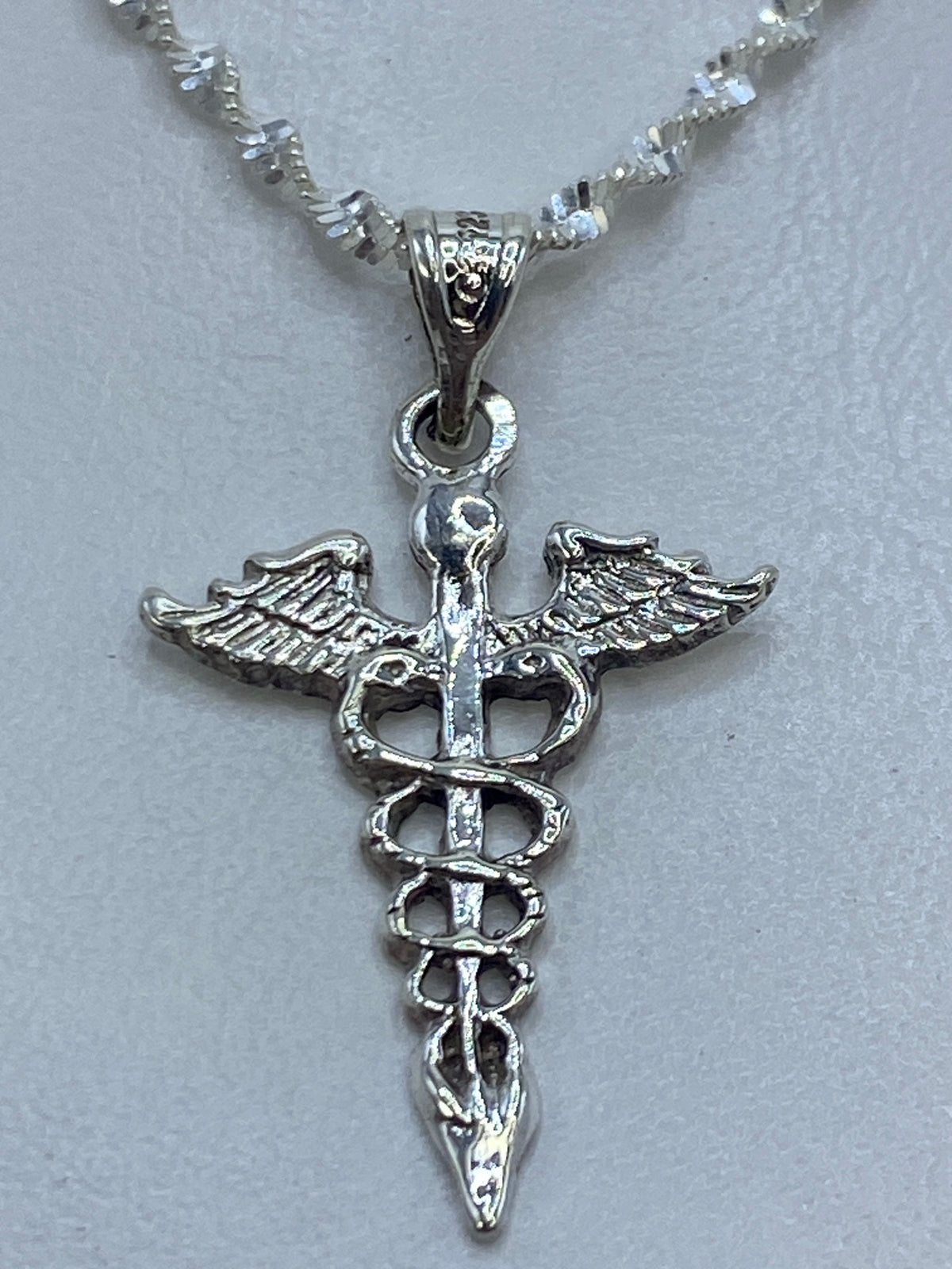 Dije caduceo de plata .925 con alas y serpientes enrolladas, sobre cadena de plata