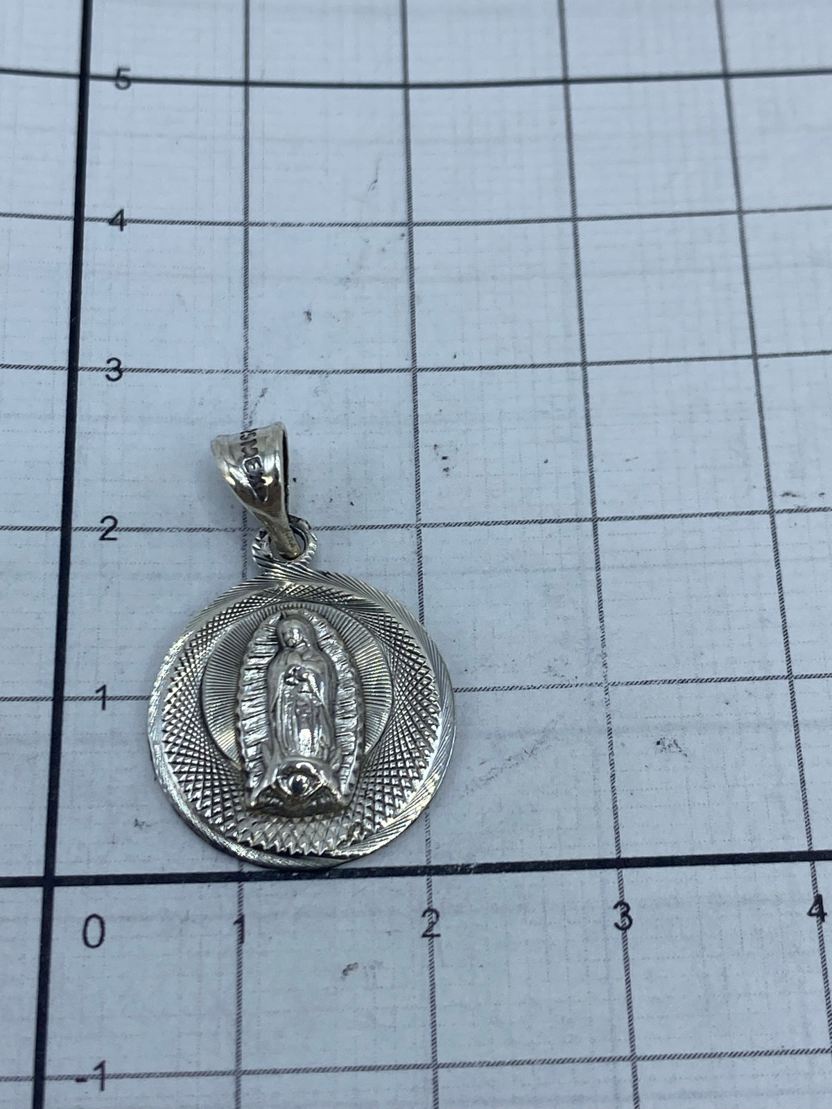 Reverso del dije de plata .925 mostrando el grabado del Quinto y acabado en relief