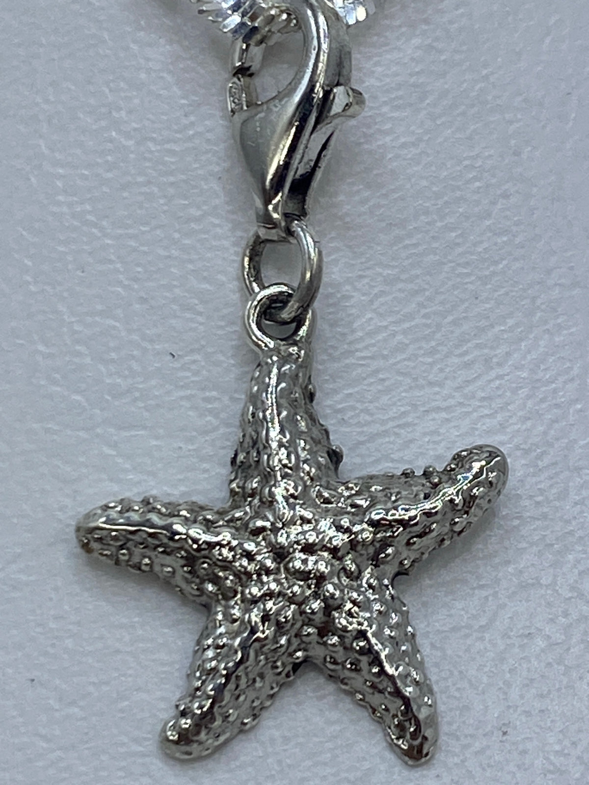 Dije de estrella de 3 cm de largo sobre una regla de medición