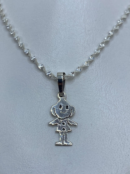 Detalle frontal de la cara sonriente grabada en el dije de plata