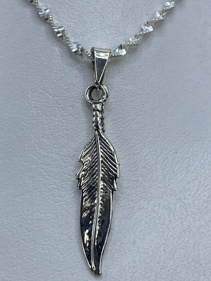 Dije de pluma en plata .925 tallado a mano, mostrado en cadena de eslabones espiral