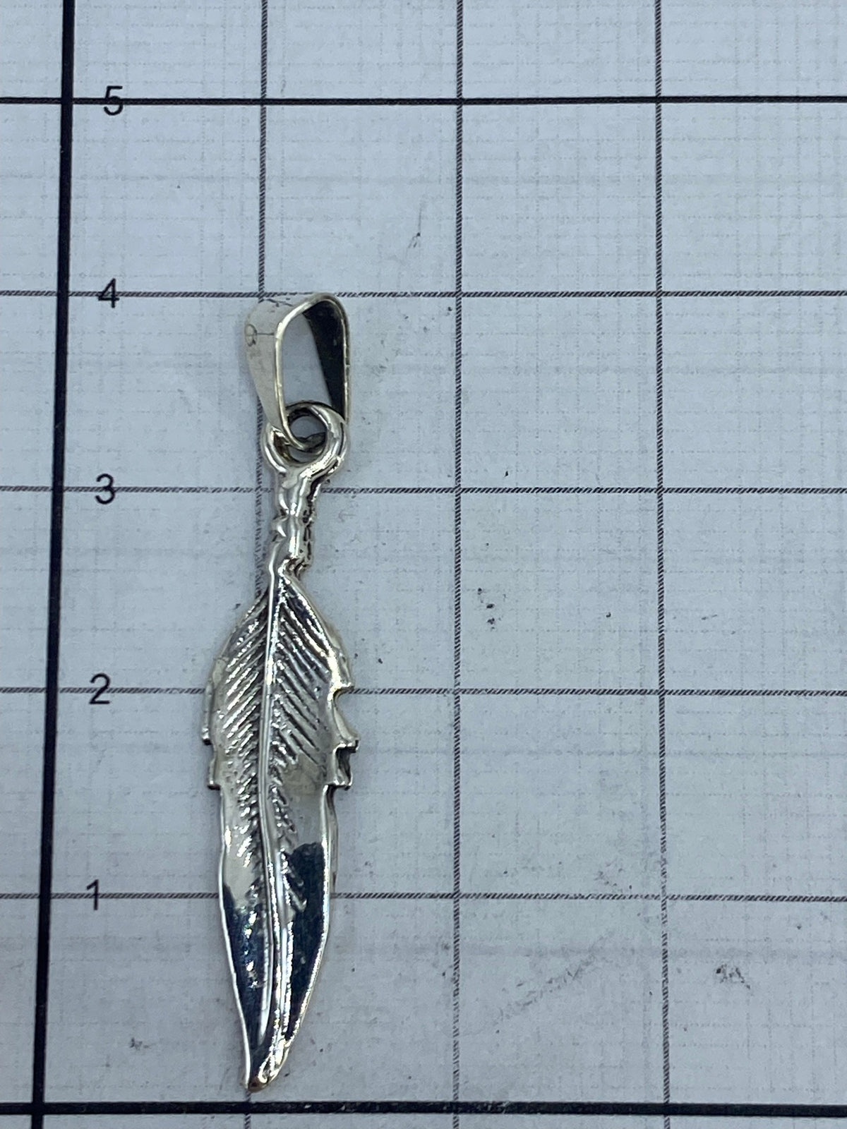 Pluma en plata .925 con Quinto visible en el enganche, fondo blanco