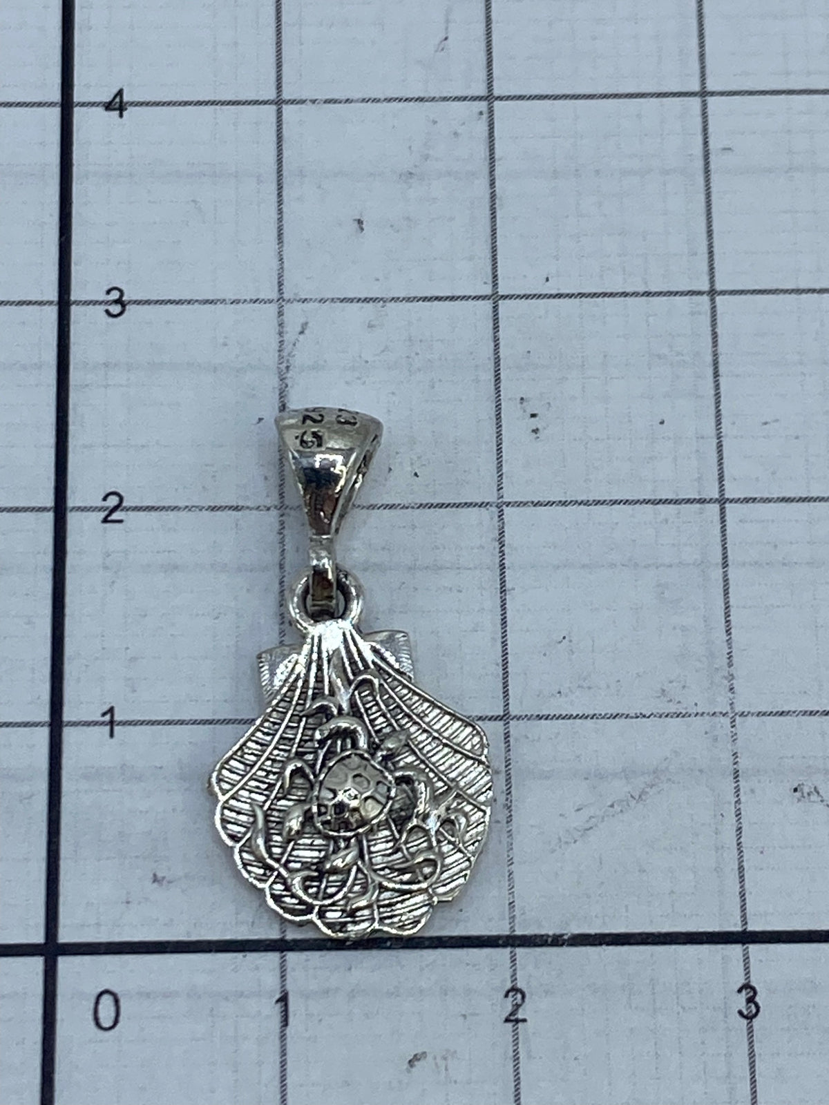 Dije de concha de plata Taxco con luz frontal, mostrando el acabado pulido