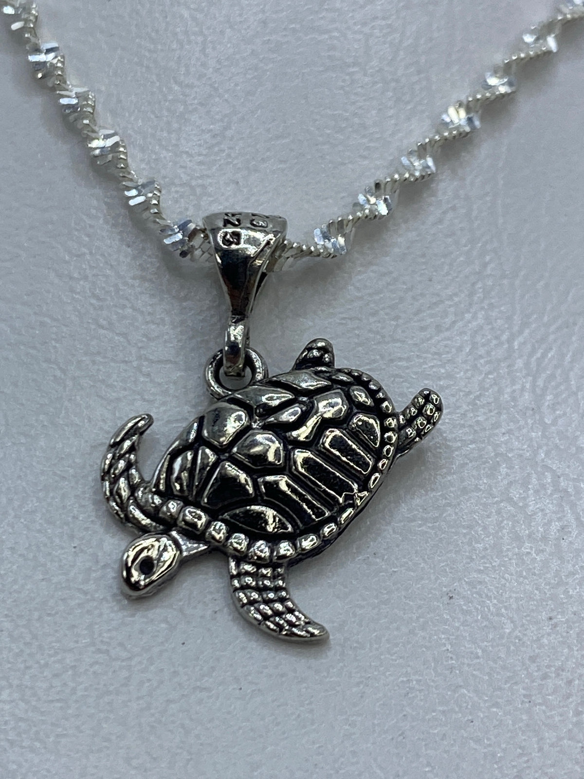 Dije tortuga de plata repujada de 2 cm, colgado de cadena plateada, detalle del caparazón en relieve