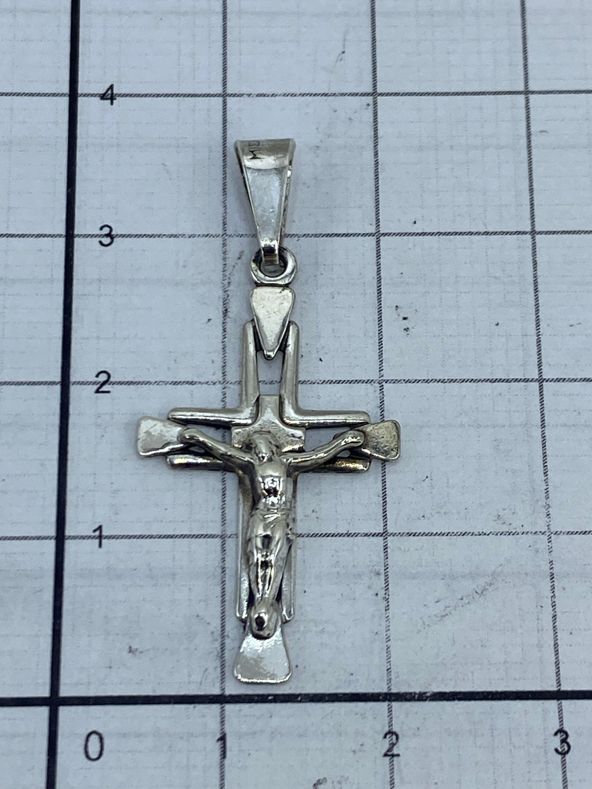 Crucifijo de plata sobre fondo blanco mostrando el Quinto 925 de autenticidad