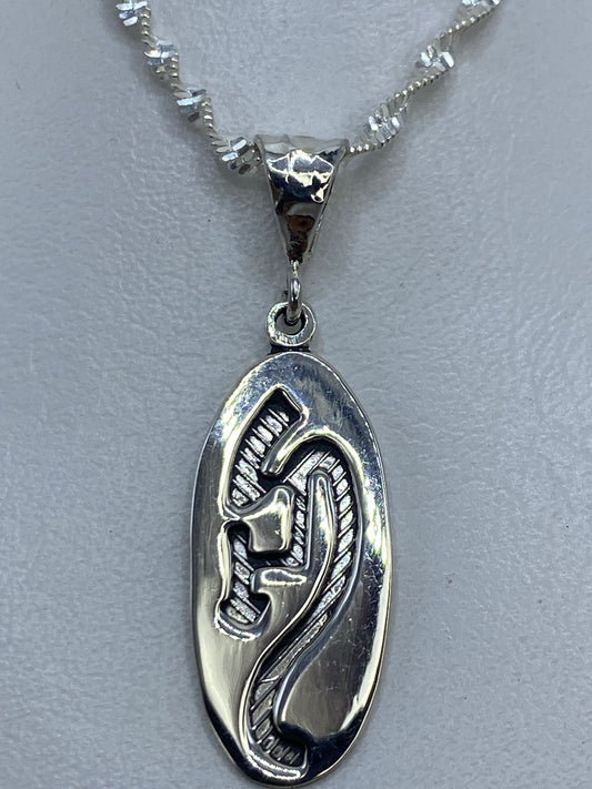 Dije de plata .925 con diseño prehispánico en relieve sobre fondo gris claro