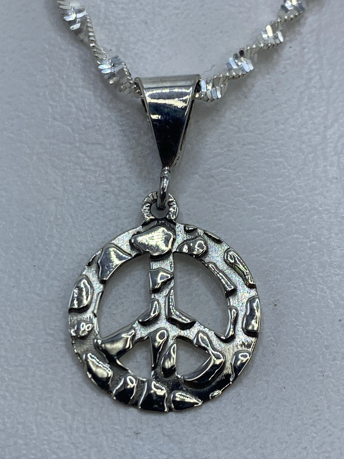 Dije símbolo de paz en plata .925 granulado de Taxco, 2 cm de largo