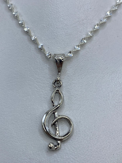 Detalle del corte de calado en el dije de clave de sol de plata .925
