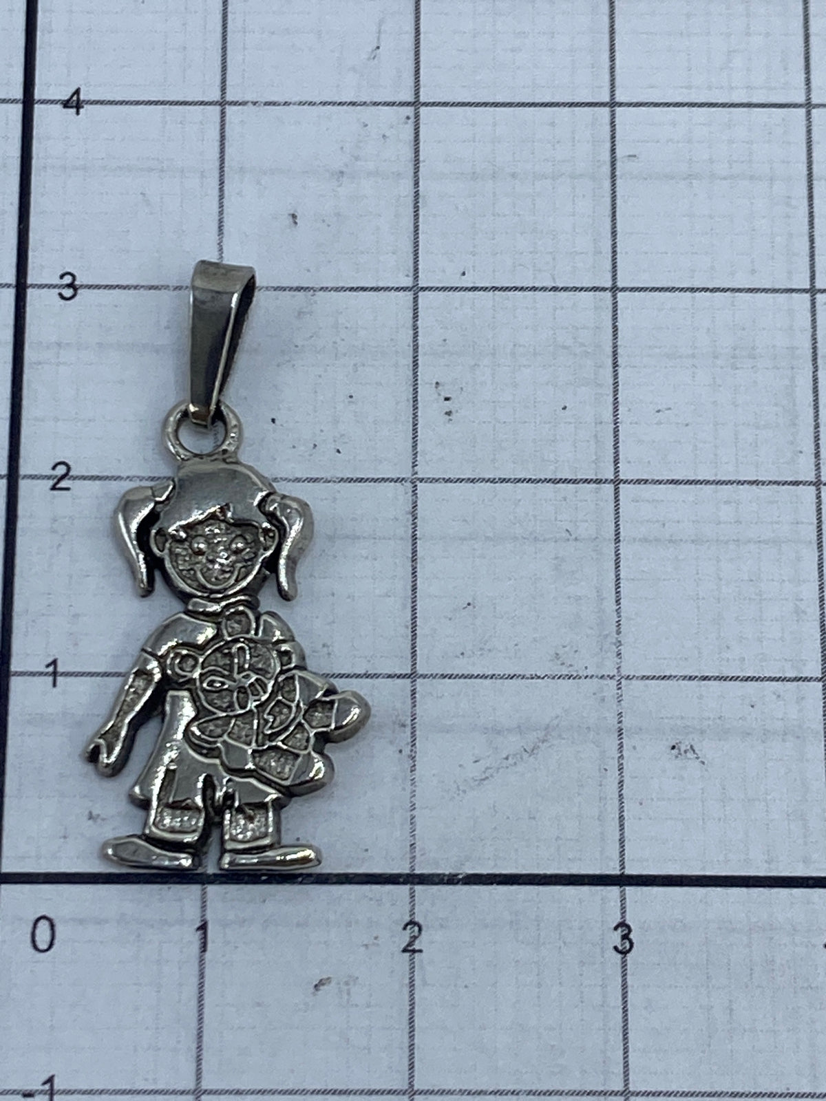 Detalle del acabado repujado en el vestido de la muñequita de plata Taxco