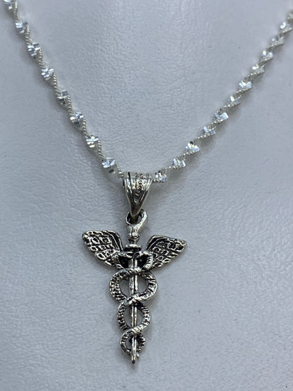 Vista frontal detallada del caduceo con alas y serpientes en plata 925