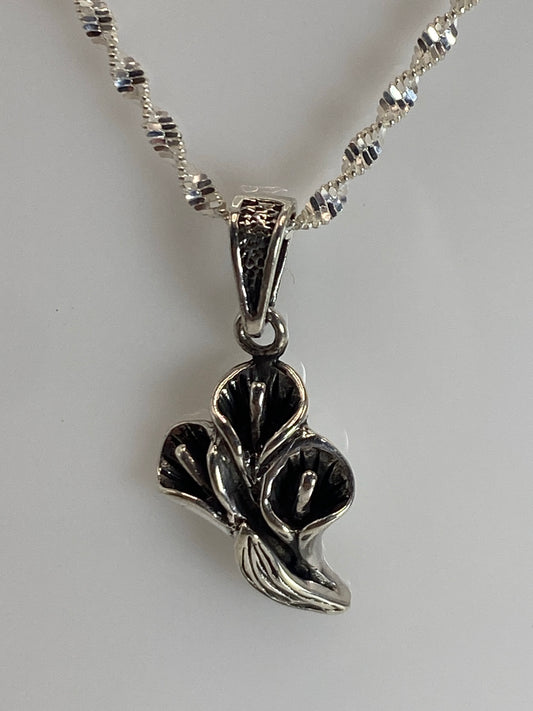 Dije floral de plata 925 con tres pétalos en relieve, colgando de una cadena torcida