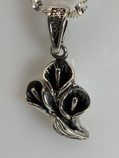 Dije floral sobre superficie clara con marca de medida de 3 cm