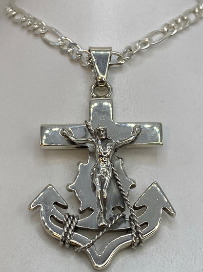 Detalle frontal del dije mostrando la cruz y los nudos marineros en plata pulida