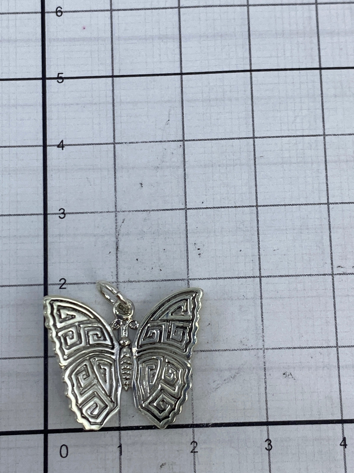 Reverso del dije mariposa con textura de repujado ancestral de Taxco