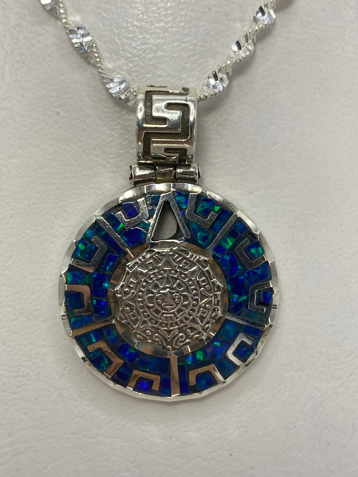 Dije de plata .950 con calendario Azteca en relieve sobre cadena de plata, colgado al cuello