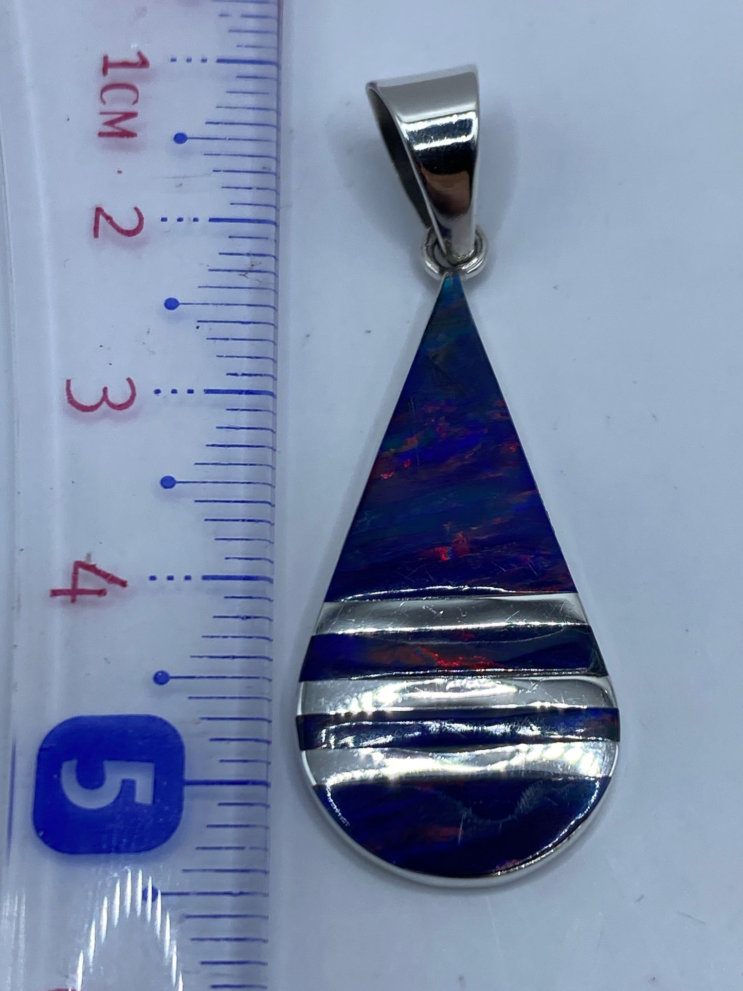 Dije de plata con Quinto .950 grabado en el reverso, sobre fondo blanco