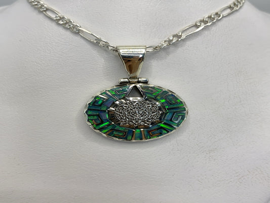 Dije de plata .950 con Ópalo de Fuego azul cielo y motivos prehispánicos labrados, colgando de una cadena figaro
