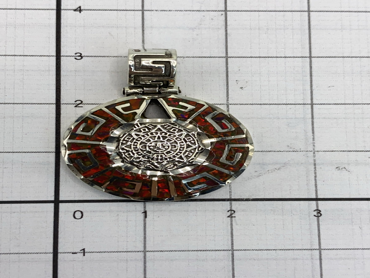 Reverso del dije mostrando el patrón prehispánico grabado y la pureza .950