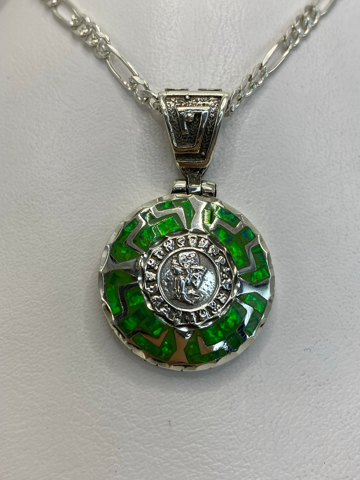Dije de plata prehispánico con ópalo de fuego verde limón, diseño circular grabado, colgante sobre fondo blanco