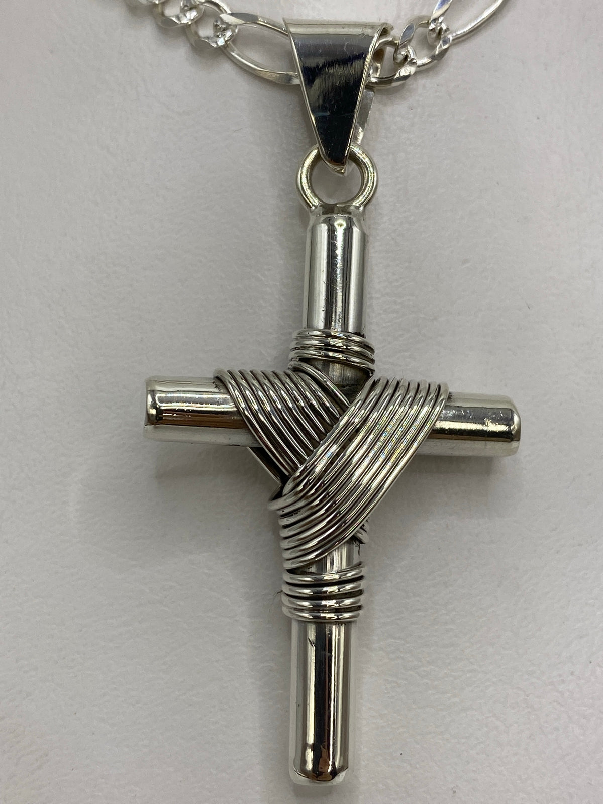 Detalle de los hilos de plata tejidos alrededor del cuerpo de la cruz