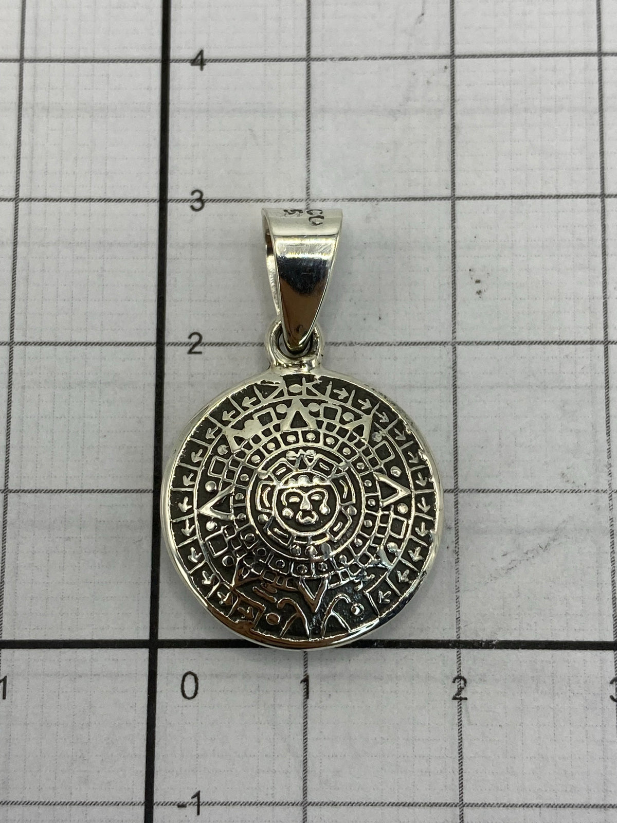 Dije de Calendario Azteca sobre fondo blanco, mostrando el anillo de conexión y el acabado pulido