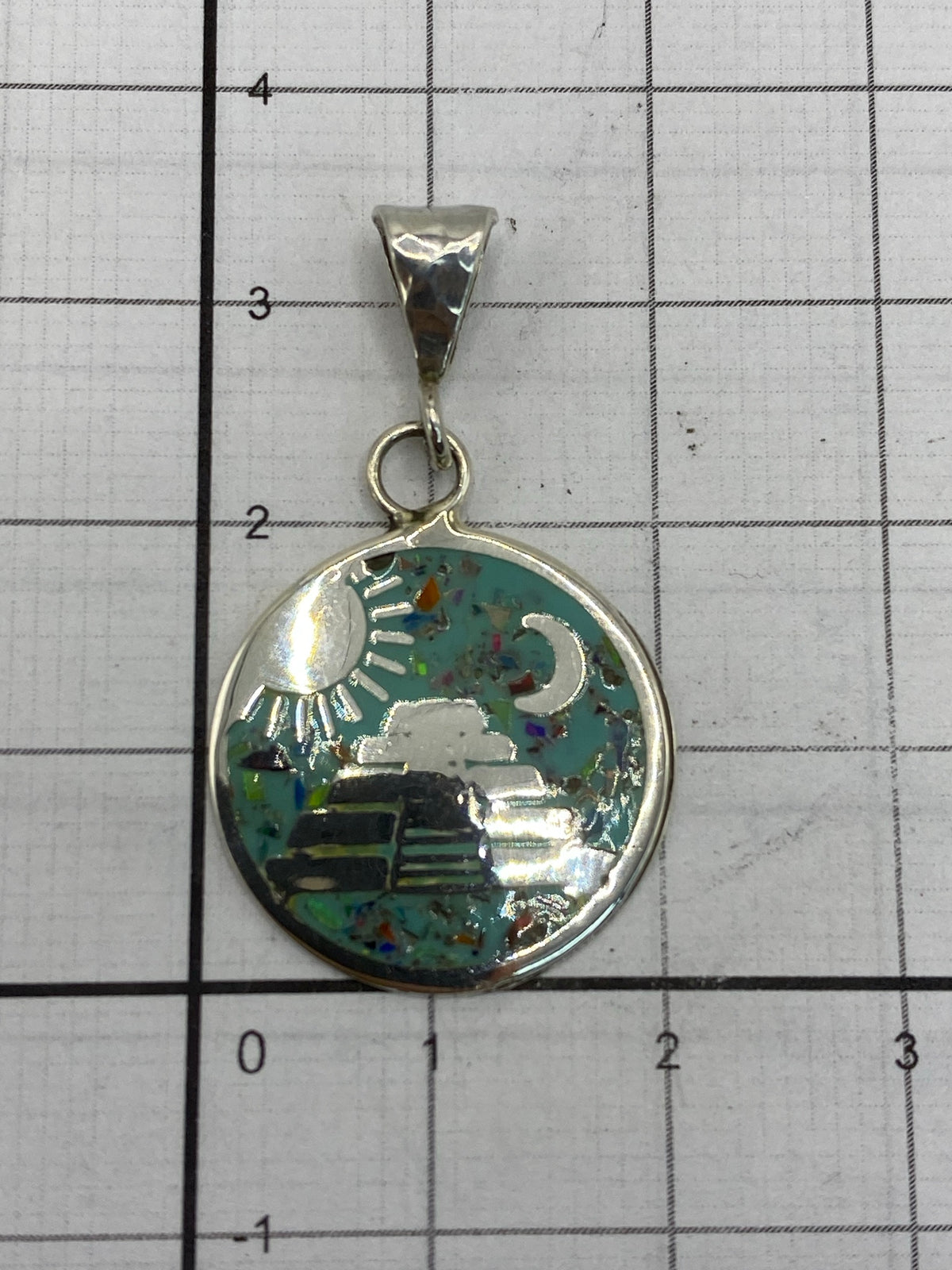 Dije de 3.5 cm sobre regla, comparado con moneda para escala de tamaño