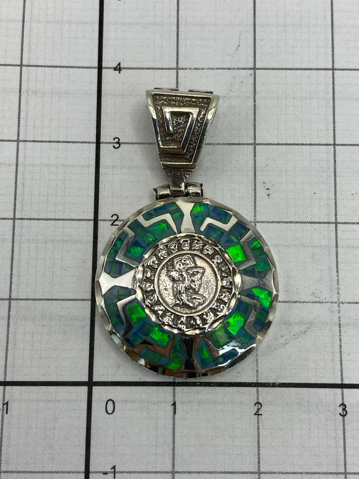 Dije sobre regla: largo 8.5 cm × ancho 2.2 cm, sin cadena