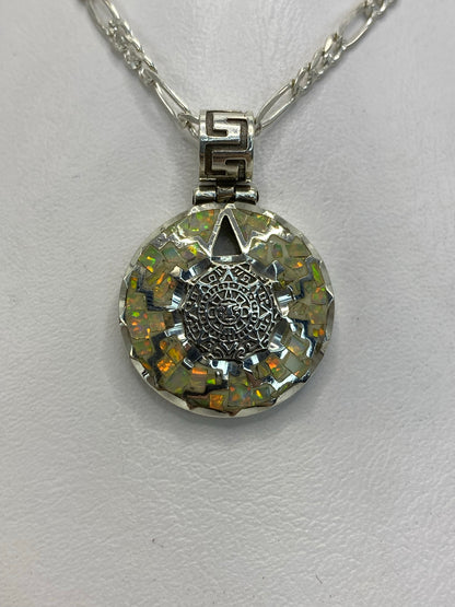 Dije de plata .950 con calendario azteca y ópalo de fuego blanco, colgado de cadena plateada