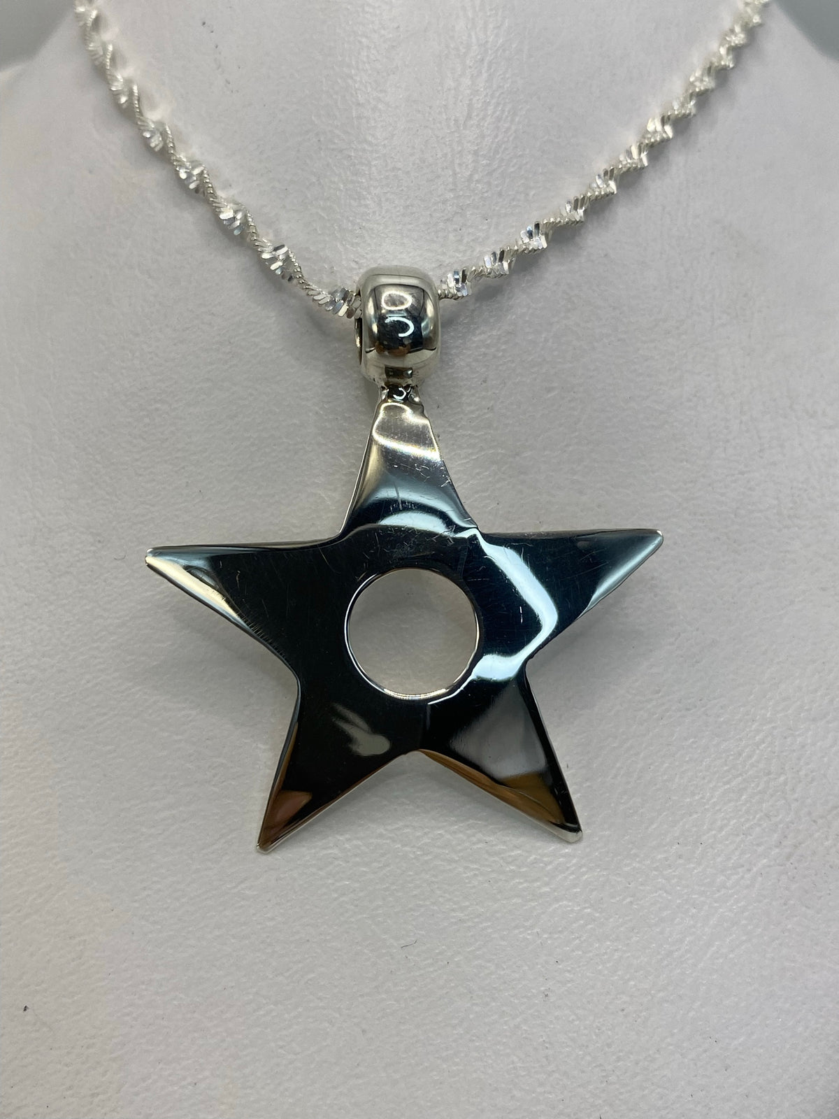 Detalle de la estrella de plata .925 mostrando el relieve geométrico