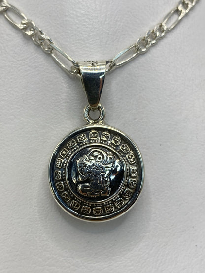 Dije de plata sobre regla, mostrando las dimensiones de 3 × 2 cm